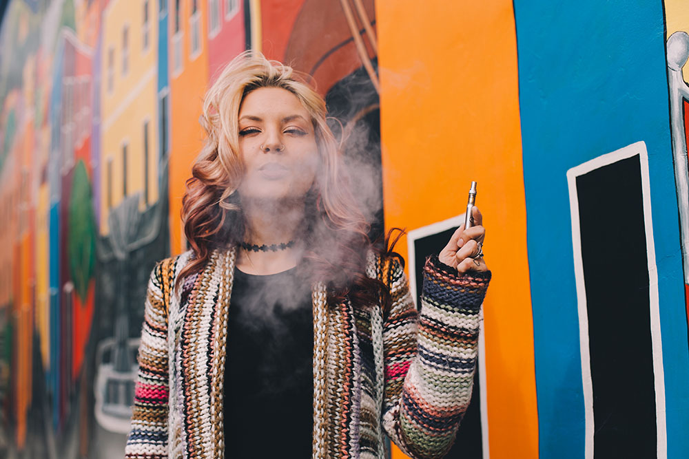 woman with blonde hair smoking vape