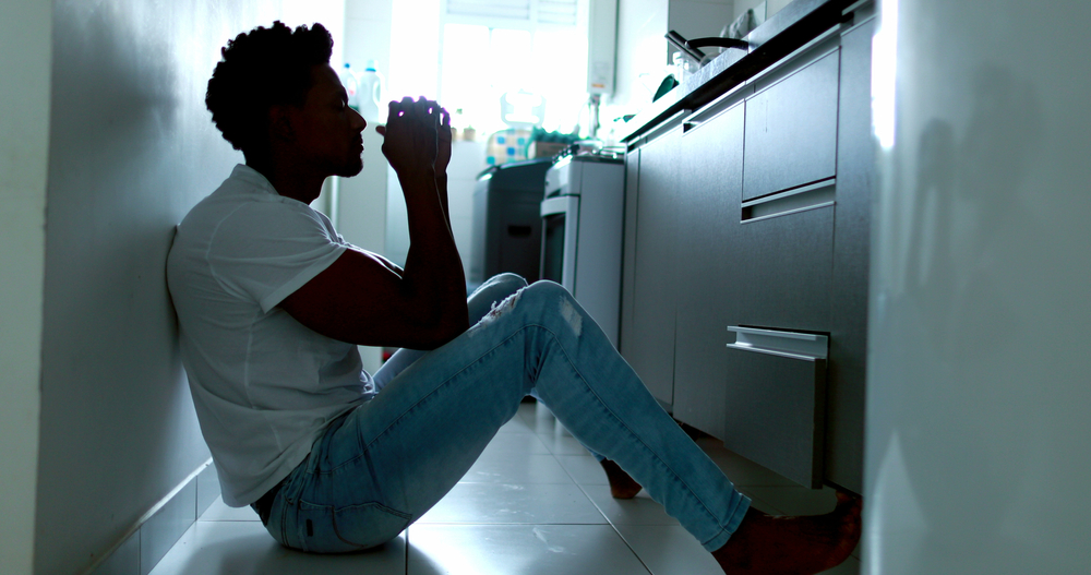 Man sitting in front of kitchen drawer