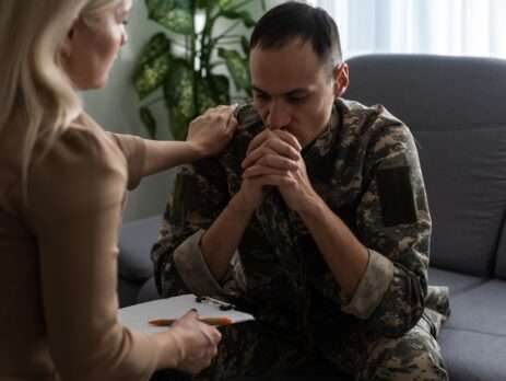 consultant holding the shoulder of a veteran