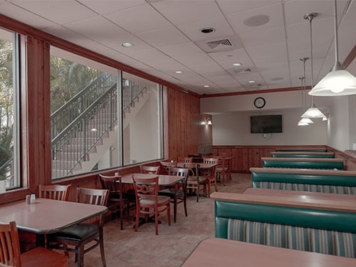 Treatment center dining room with tables, chairs, and booth seating