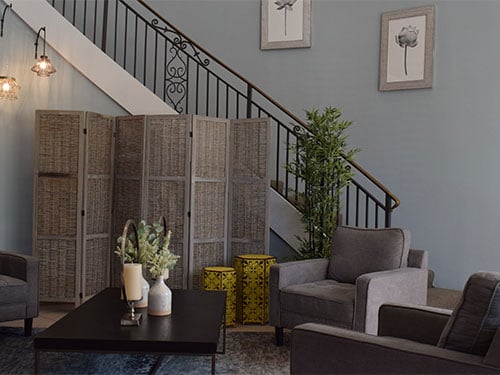 Comfortable facility lounge with armchairs and a decorative staircase