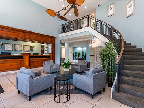 Comfortable facility lobby with seating area and curved staircase